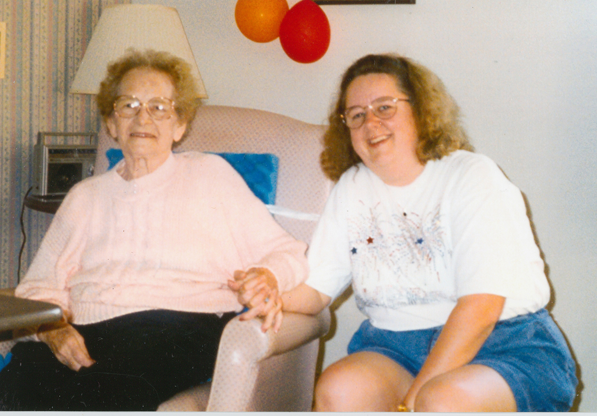 two women seated in living room, smiling